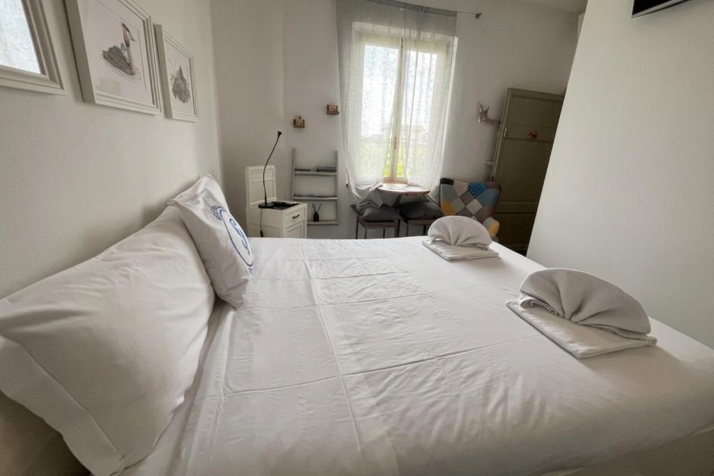 a white bed with two pillows on top of it at Casa Porto Vecchio in Peschiera del Garda