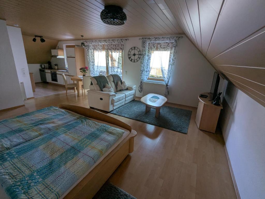 a bedroom with a bed and a living room at FeWo am Heimlisberg in Friesenheim