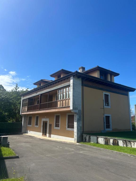 a large building with a balcony on the side of it at Apartamento La Marquesa in Llanes