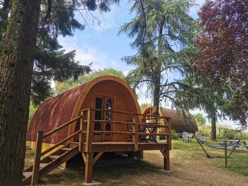a small wooden cabin in a forest with trees at La Cabane MIMOSA in Saint-Malo-du-Bois