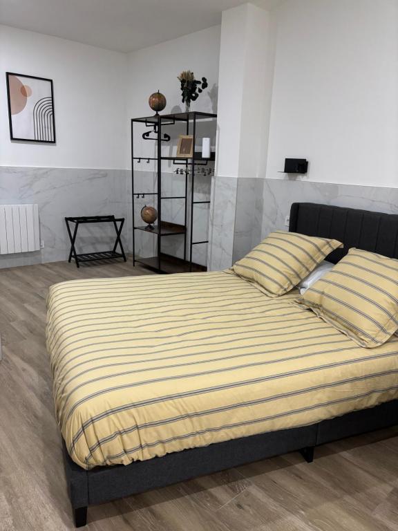 a bedroom with a large bed with yellow and white sheets at URDAIHOME SUITES & BIKEs in Guernica y Luno