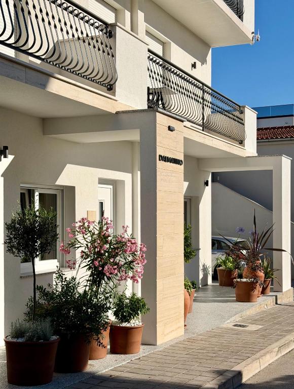 a building with potted plants on the side of it at Apartments & Studios Dalmatino in Vodice