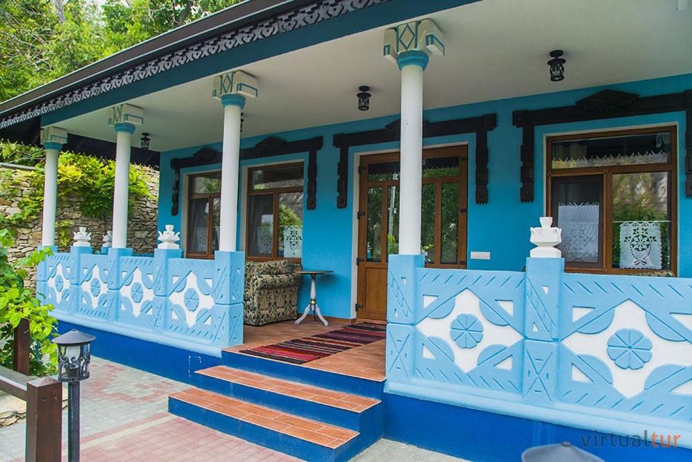 niebieski dom ze schodami przed nim w obiekcie Resedinta Rotundu w mieście Butuceni