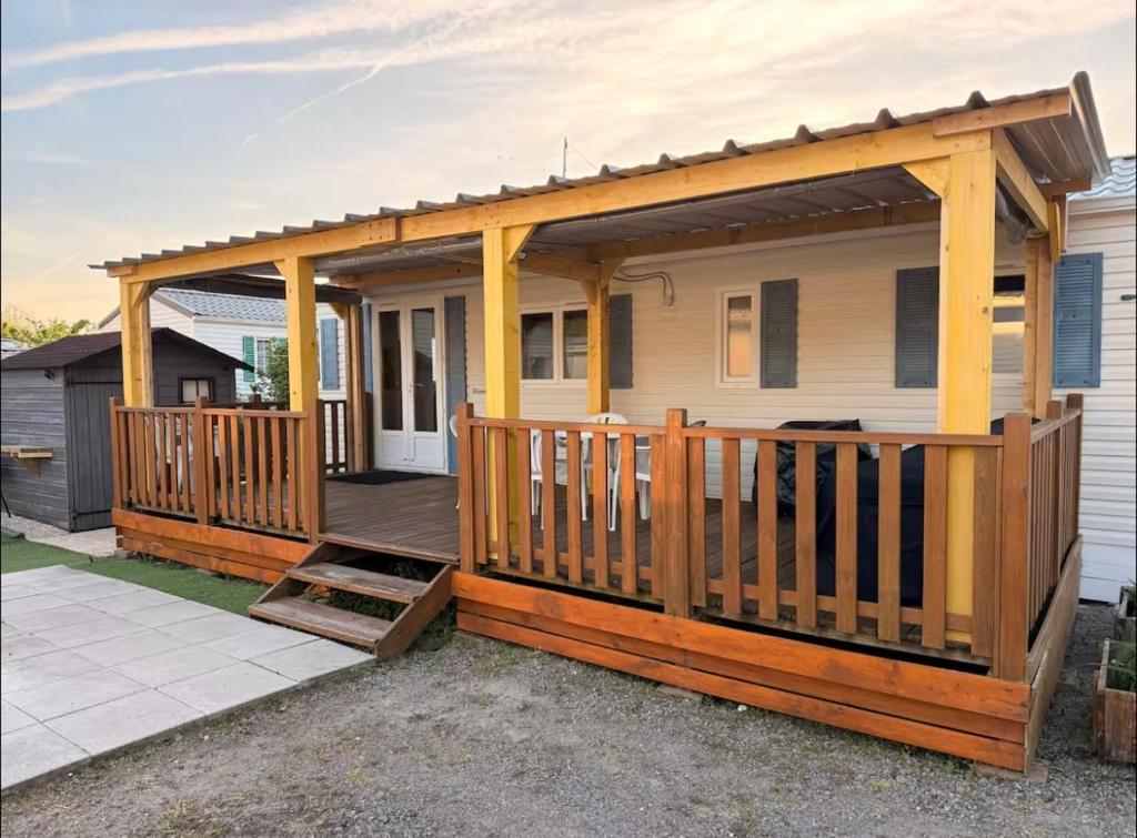 a wooden deck with awning on a house at Bungalow à la mer in Villeneuve-en-Retz