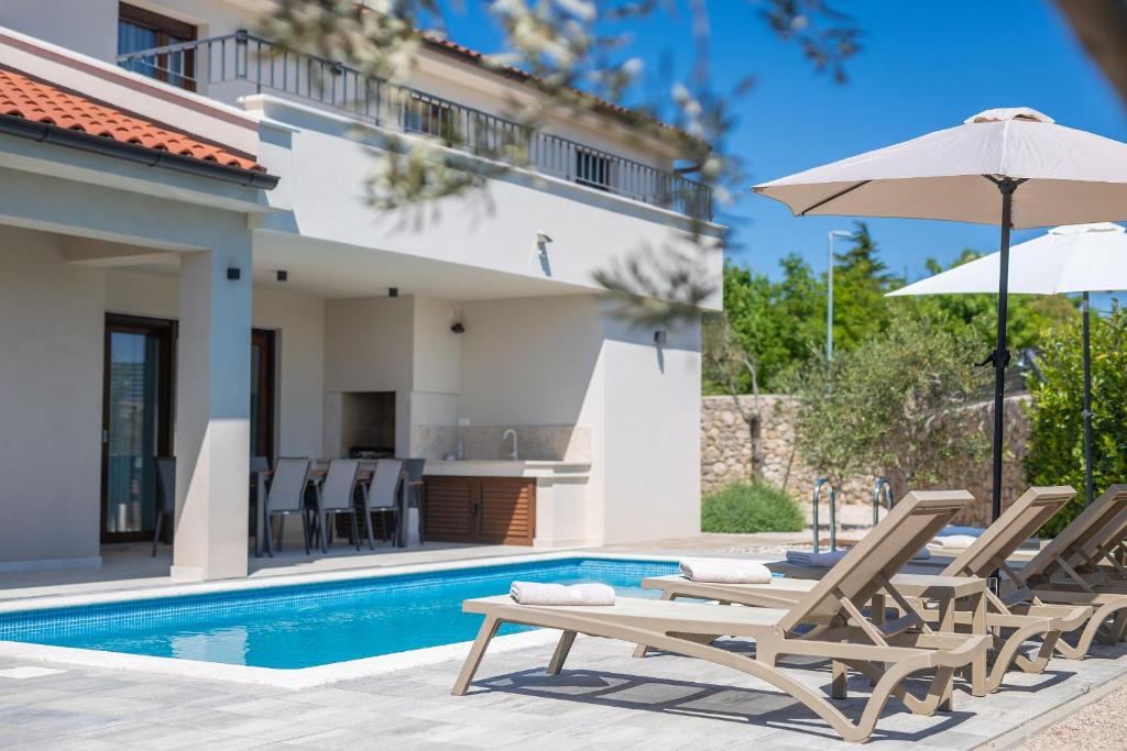 a villa with a swimming pool and patio furniture at Villa Monika in Krk