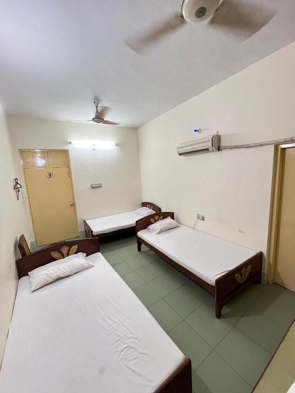 a room with two beds and a door in it at Adeel hotel & Restaurant Mianwali in Bānda Arāīyān