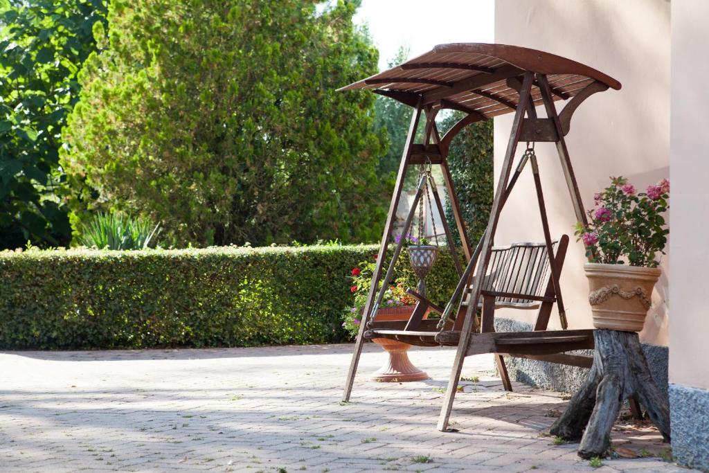 a wooden swing sitting next to a building at Agriturismo Artisti Del Cavallo in Foiano della Chiana