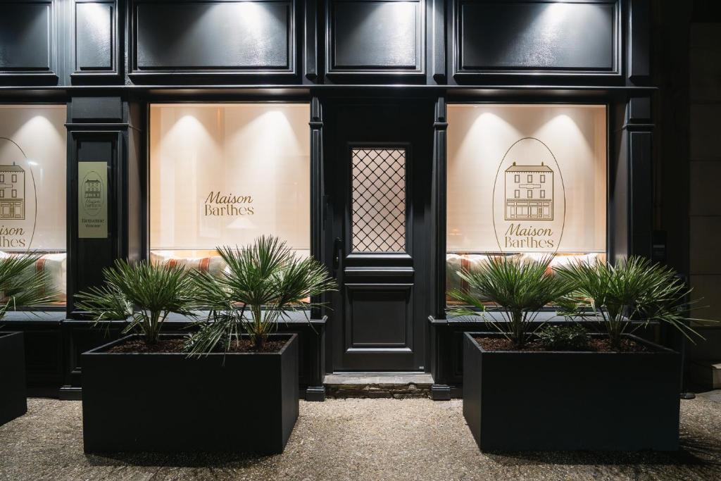 a store front with potted plants in front of it at Maison Barthes Suites B&B in Baraqueville