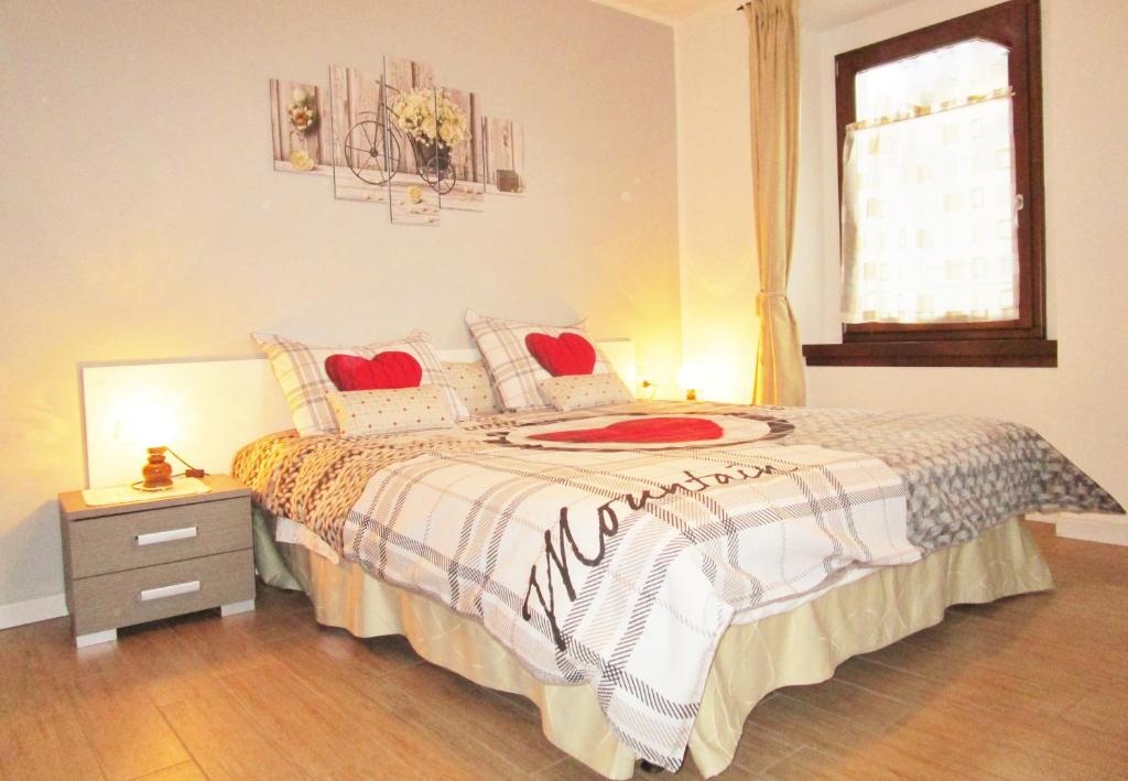 una camera da letto con un letto con cuori rossi sopra di Casa Dantina Stenico a Stenico
