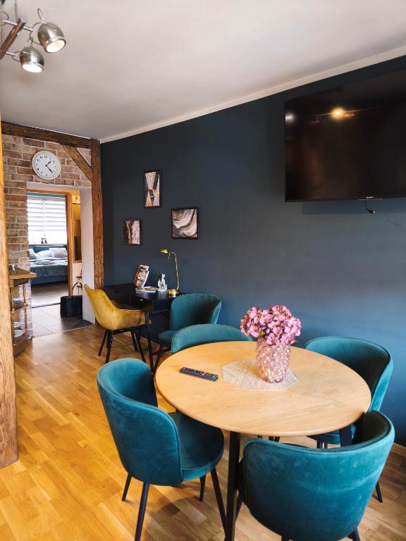 a dining room with a table and blue chairs at Apartamenty Centrum Nowa Ruda No1 in Nowa Ruda