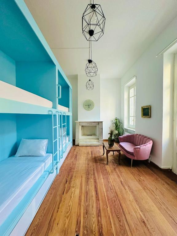 sypialnia z niebieskim łóżkiem i różowym krzesłem w obiekcie Pink Pineapple Hostel w Atenach