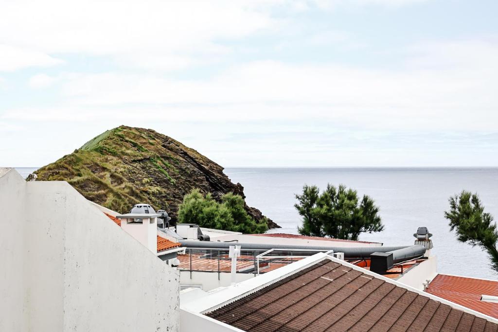 a view of the ocean from the roofs of houses at Casa a 2 minutos a pé de piscina natural in Ponta Delgada