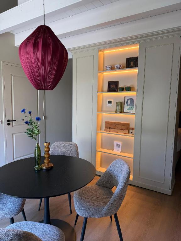 a dining room with a table and chairs and a purple lamp at Maison Cromvoirt in Cromvoirt
