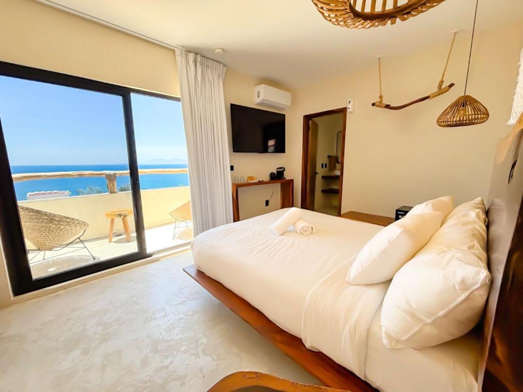 a bedroom with a bed with a view of the ocean at Hotel Boutique Alcalá Vallarta in Puerto Vallarta