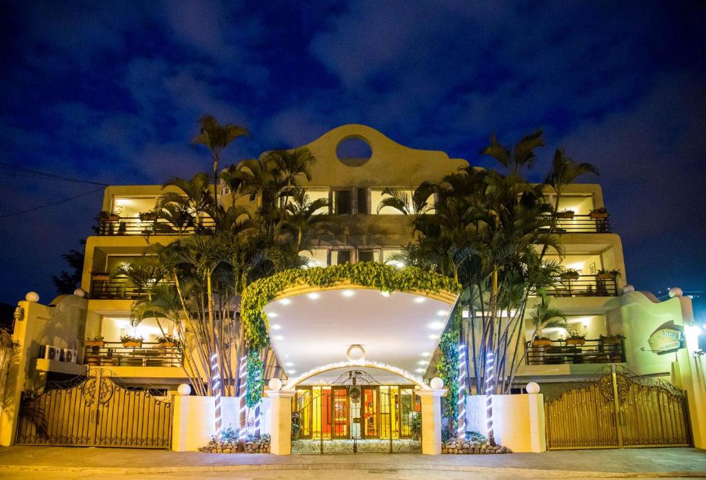 un edificio con una entrada delantera con palmeras en Apart-Hotel Casa Serena en Guatemala