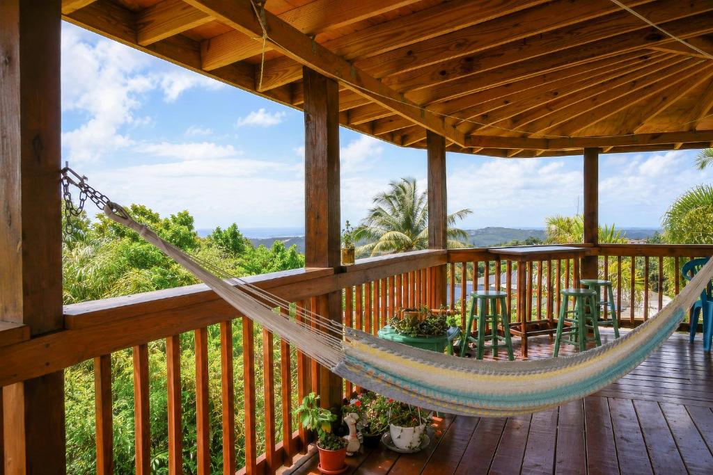 a hammock on the deck of a cabin at New Mountain Escape Panoramic San Juan Views in Aguas Buenas