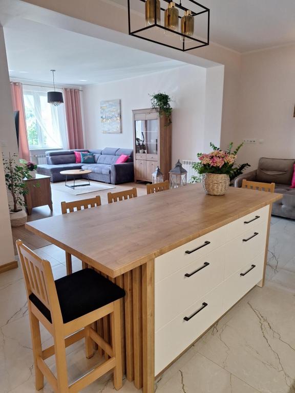 a kitchen and living room with a table and chairs at Apartament przy Jeziorku Magistrackim in Mrągowo