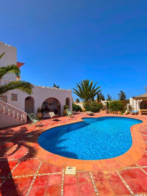 a swimming pool in front of a villa at Nanou in Zarzis