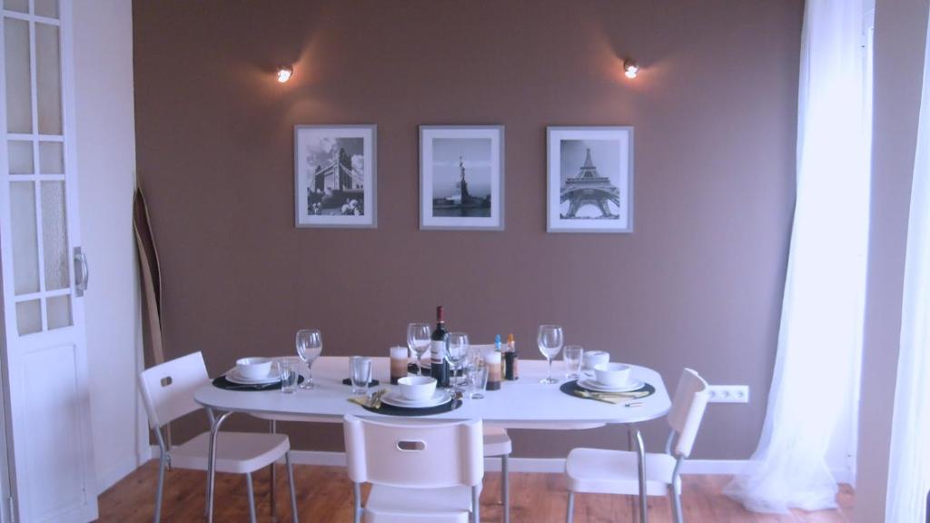 a table with white chairs and a white table with wine glasses at Calatrava in Valencia