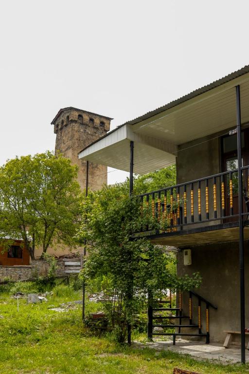 a building with a staircase and a tower at Guest House Adelina in Mestia