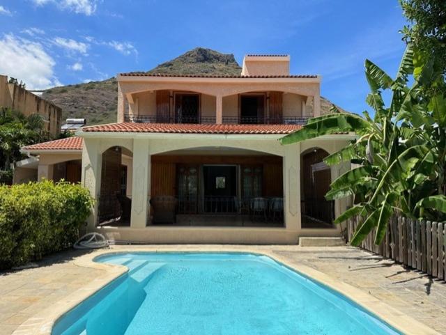 a house with a swimming pool in front of a house at Dodo Casita House in Tamarin