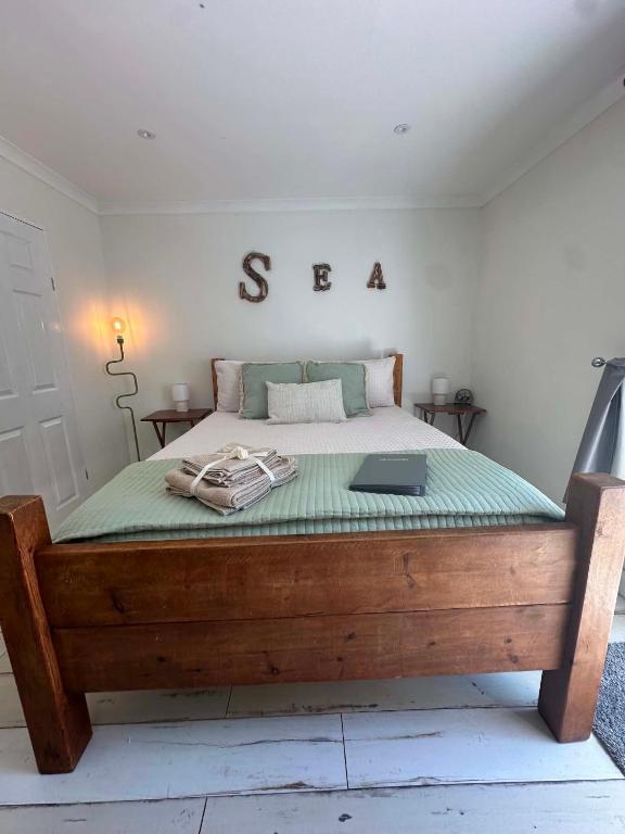 a bedroom with a bed with a sign on it at Rūm by the beach in Camber