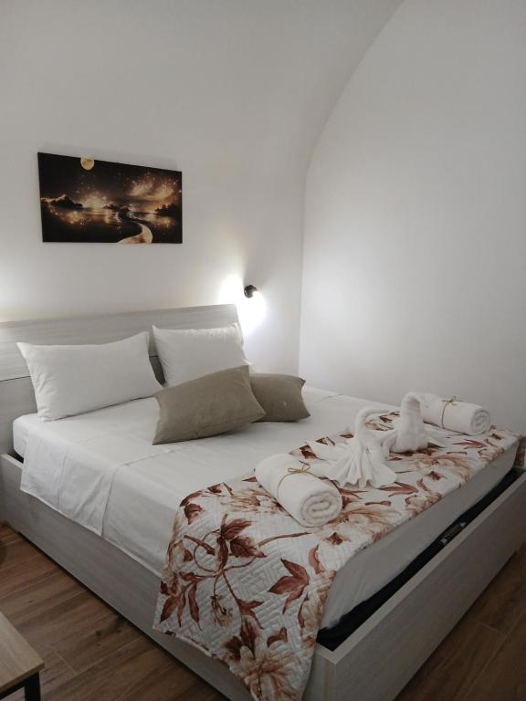 a white bedroom with a large bed with white sheets at CASA NiNì in Trani