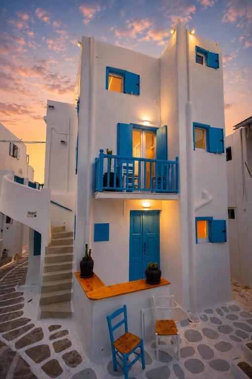 a building with blue doors and stairs in front at Panda Blue&White Downtown in Megali Ammos