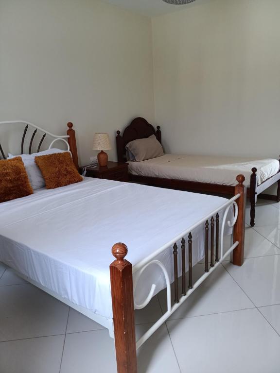 two twin beds in a room with white walls at Selma Space in São Filipe
