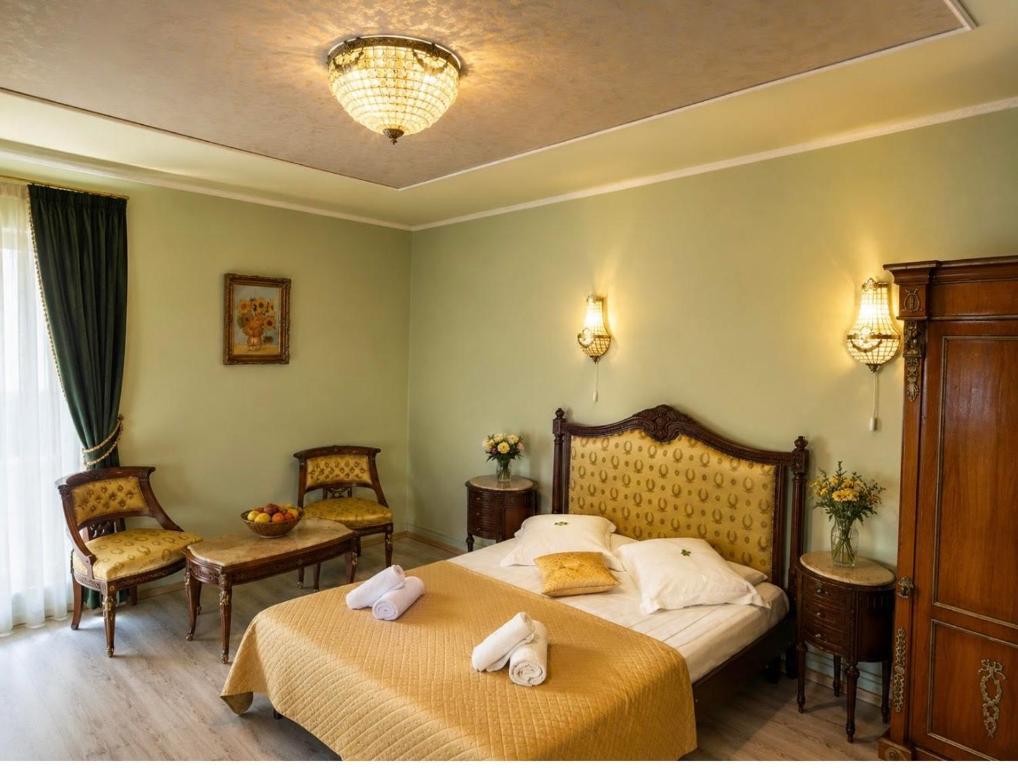 a hotel room with two beds and two chairs at Pensiunea Cardinal in Sibiu