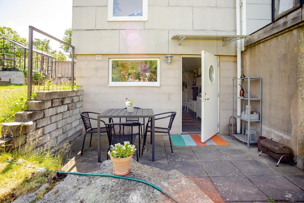 a patio with a table and chairs in front of a building at Cozy summer apartment in Archipelago in Öckerö