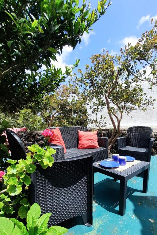 a patio with a couch and a table and chairs at Quinta do Norte - Biscoitos in Biscoitos