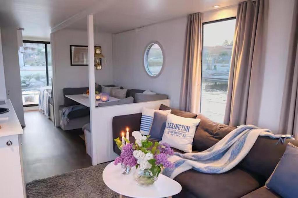 a living room with a couch and flowers on a table at Solvesborg Houseboat with Harbour Views - Sleeps 4 in Sölvesborg