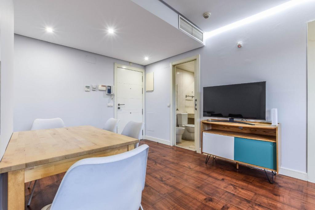 a dining room with a table and a television at The Corporate Residence & Parking in Madrid