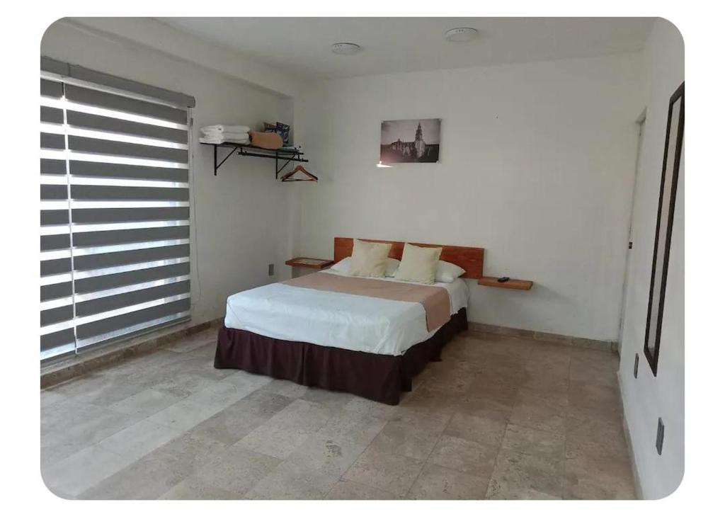 a bedroom with a bed in the corner of a room at Casa Don Alfonso in Cuernavaca
