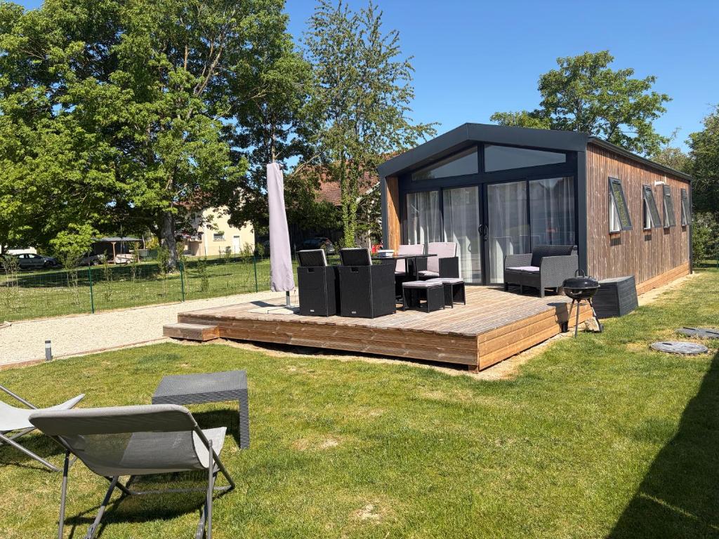 a gazebo with chairs and tables in the grass at Chalet Bois in Torcy-le-Petit