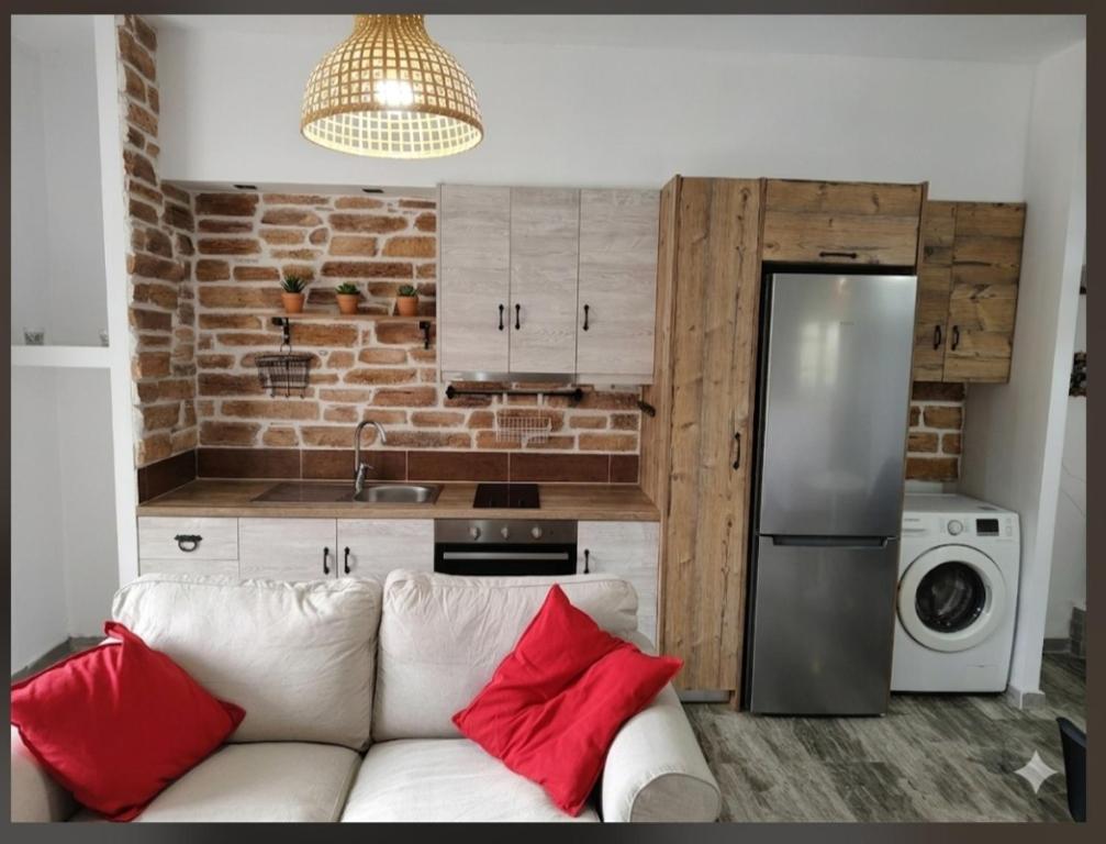 a white couch with red pillows in a kitchen at Olea Heaven Aliveri in Aliveri