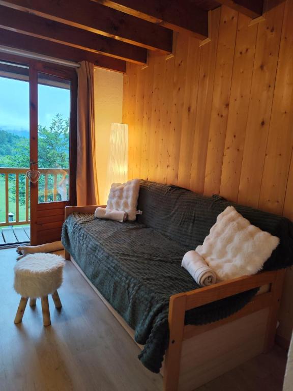 a bedroom with a bed and a large window at L'Esprit Chalet in Ustou