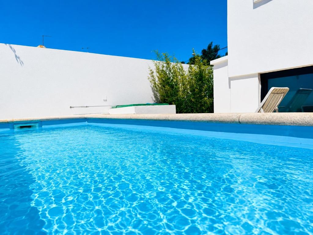 a swimming pool in front of a house at Aomo-casa parede in Parede