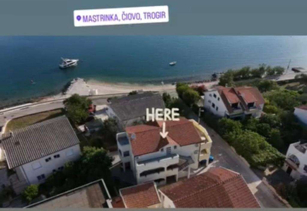 a view of a beach with a boat in the water at Apartmani BRNADA in Trogir