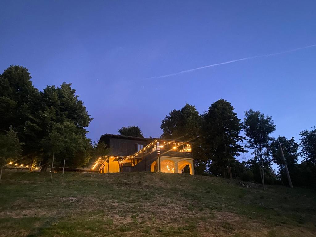a house on top of a hill at night at Shangri-La Travellers' Hostel in Castel dellʼAlpi