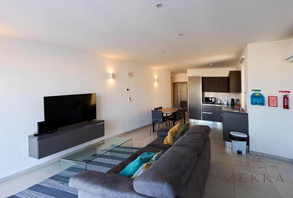 a large living room with a couch and a television at Large 3BR Flat with Exceptional Marina Views in Tal-Pietà