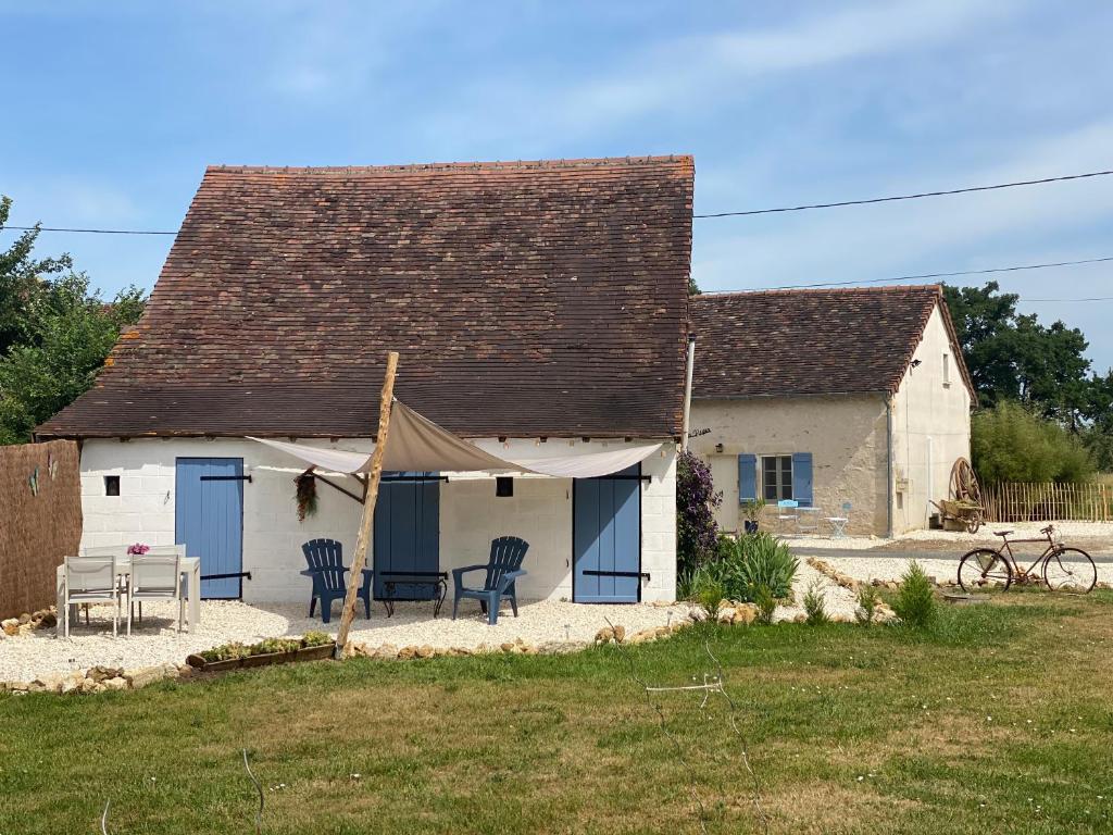 a white house with a table and chairs in a yard at Mon Repos, onze sfeervolle gîte in Haims