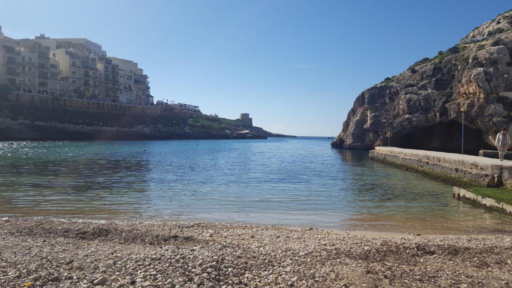 a body of water next to a rocky beach at Mobydick Apartments by RBG in Xlendi