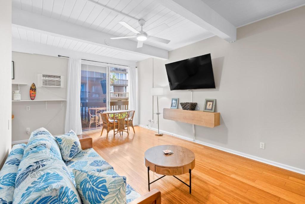 a living room with a blue couch and a table at Kona Mansions#208 in Kailua-Kona