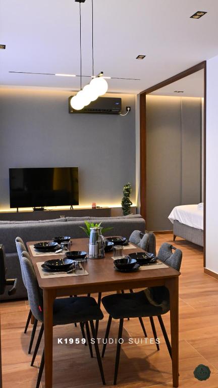 a dining room with a table with chairs and a television at K1959 Studio Suites in Peje