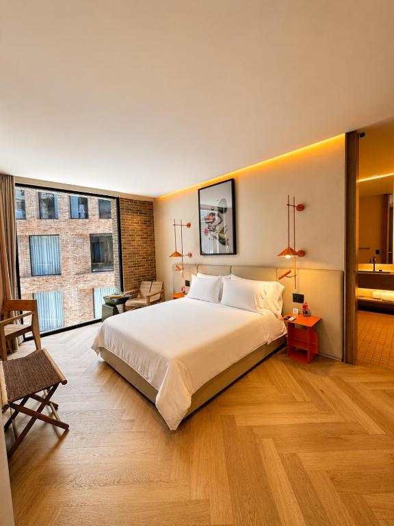 a bedroom with a large bed and a large window at The Cut Hotel in Medellín
