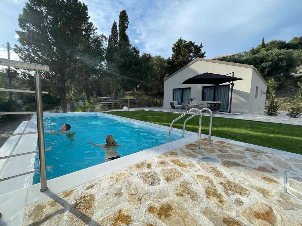 a family in a swimming pool in a house at Villa Rinoula-private pool in Vitalades