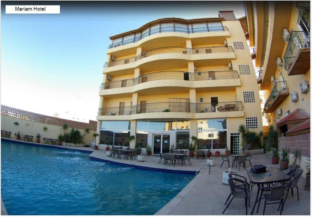 a building with a swimming pool next to a hotel at Mariam Hotel in Madaba