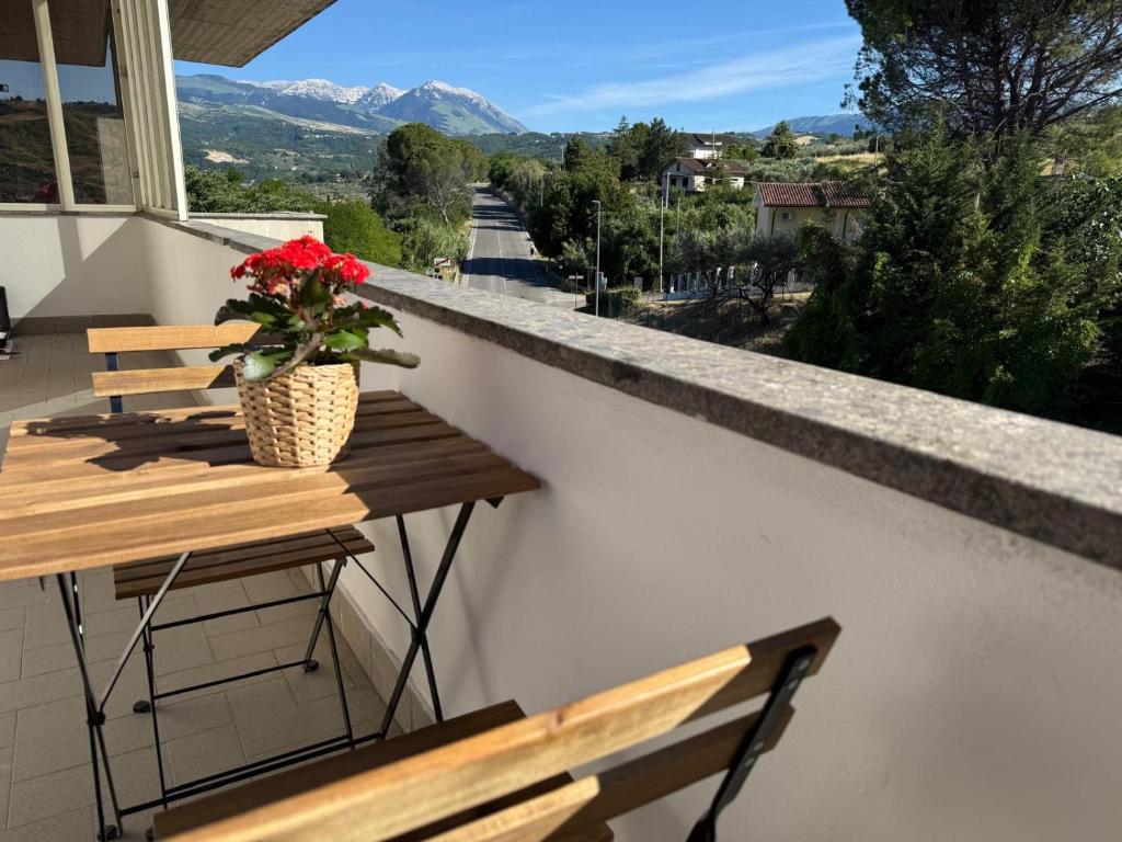 a balcony with two benches and a vase with red flowers at Casa Dulce Casa - Bright flat with balcony 2 baths 2 beds in Scafa